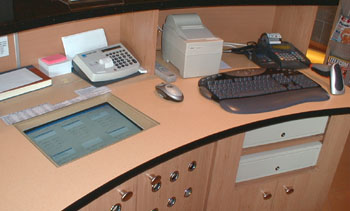 A pult l�that� a k�pen. (puzltba �p�tett monitor, nyomtat�, vonalk�d olvas� �s az automatikusan nyil� kassz�k)